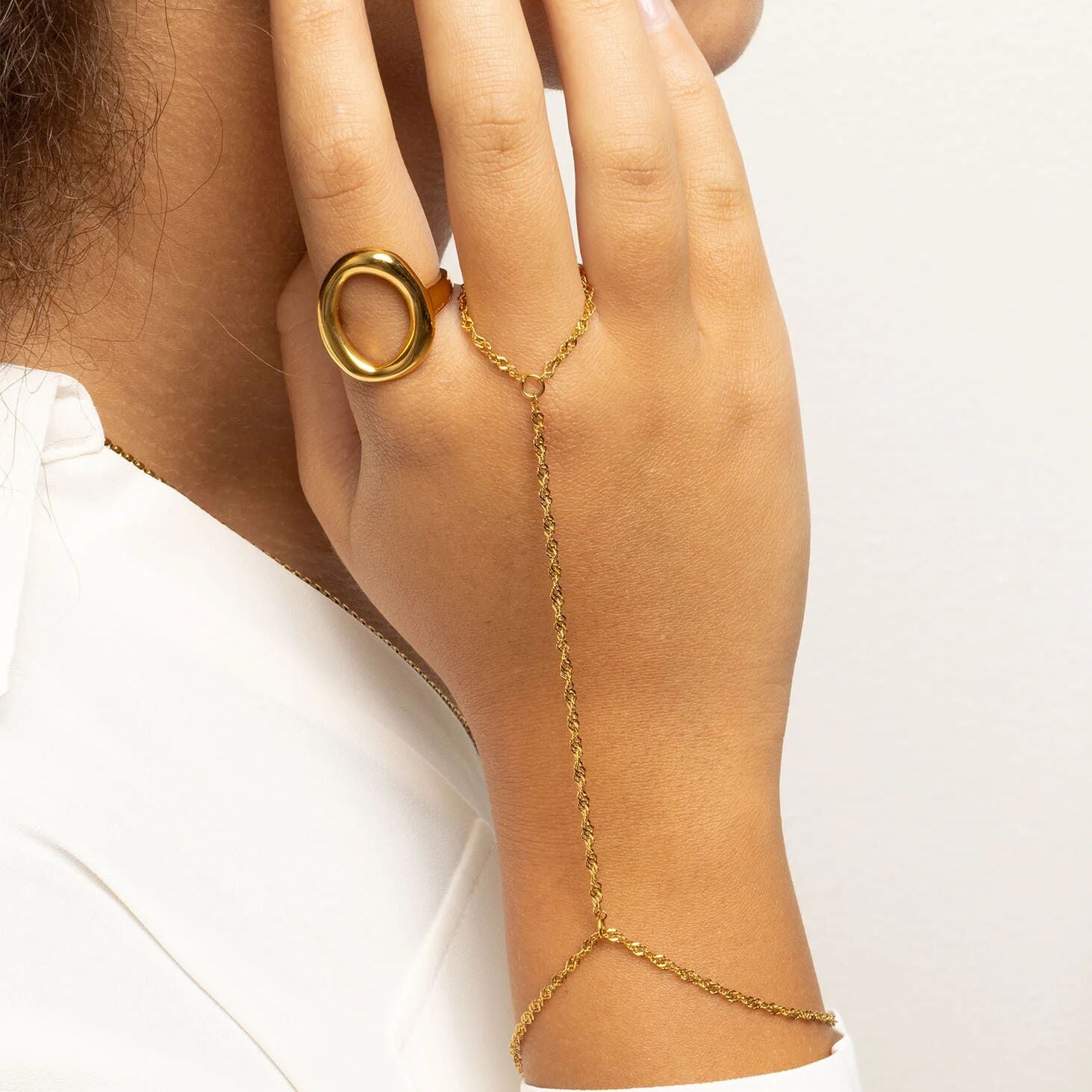 Gold Singapore Hand Chain on a hand against a white background