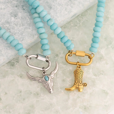 Two necklaces with charm pendants on a marble surface