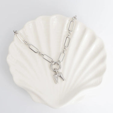 Silver bracelet with a charm on a white shell