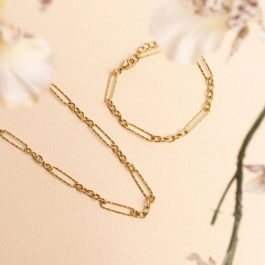 Gold chain necklace on a beige background