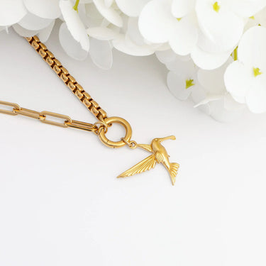 Gold necklace with a hummingbird pendant on a white background