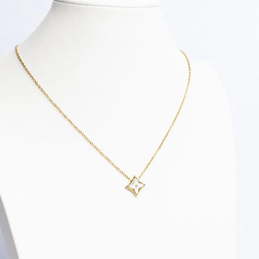 Gold necklace with a star-shaped pendant on a mannequin bust against a white background