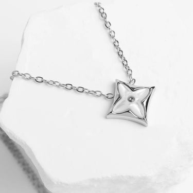 Silver necklace with a star-shaped pendant on a white background