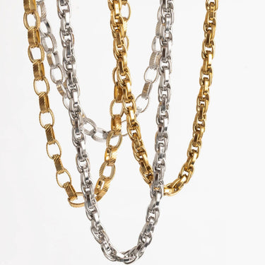 Two gold and two silver chain necklaces on a white background