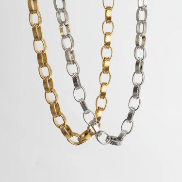 Two gold and silver chain necklaces on a light gray background