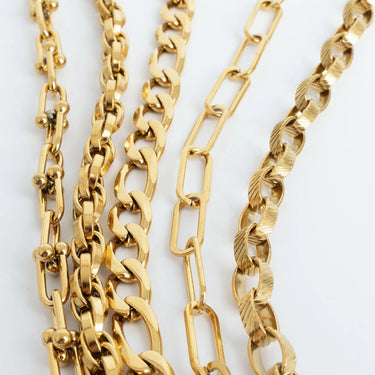 Three gold chain necklaces on a white background