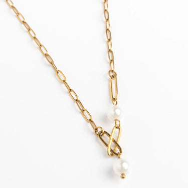 Gold chain necklace with pearls on a white background