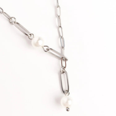 Silver chain necklace with pearls on a white background