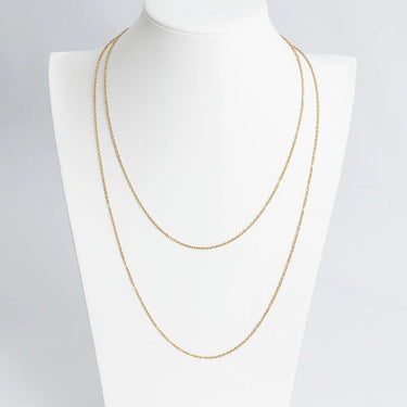 Gold chain necklace on a mannequin with a plain background