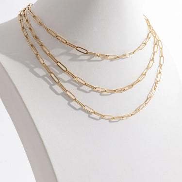 Gold chain necklace on a mannequin neck against a white background