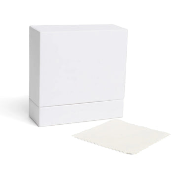 Closed white jewelry box displaying dust cloth to the side on a white background