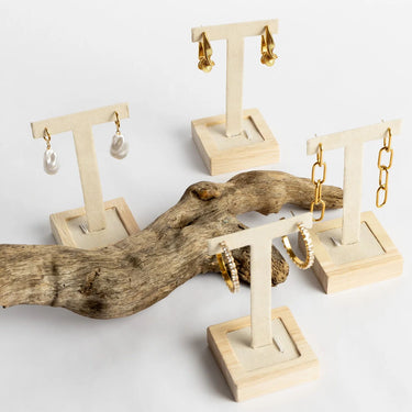 Wooden earring stands with gold earrings on a white background