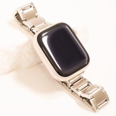 Gold watch band with black face on a white background