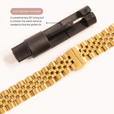 Gold watch band with black link adjuster on a white background