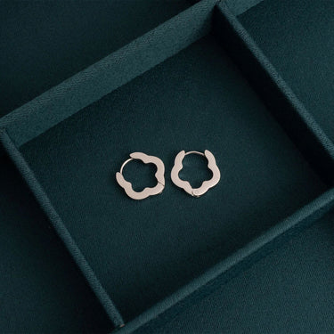 Silver hoop earrings on a dark green jewelry box