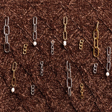 Gold, silver, and brass chain links on a brown textured background