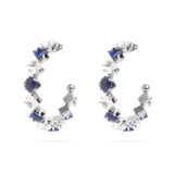 Pair of silver hoop earrings with blue gemstones on a white background
