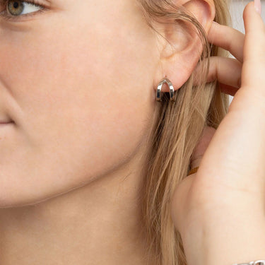 Close-up of a person wearing a silver hoop earring.