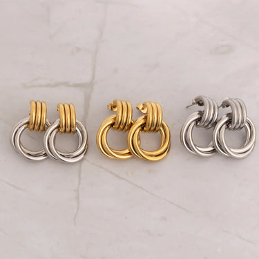 Pair of hoop earrings in gold and silver on a light marble background