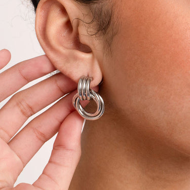 Close-up of a silver hoop earring worn by a person.