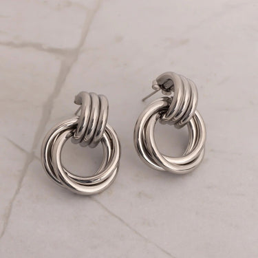 Pair of silver hoop earrings on a light marble background