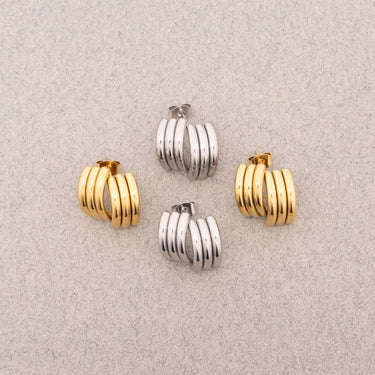 Set of gold and silver hoop earrings on a light gray background