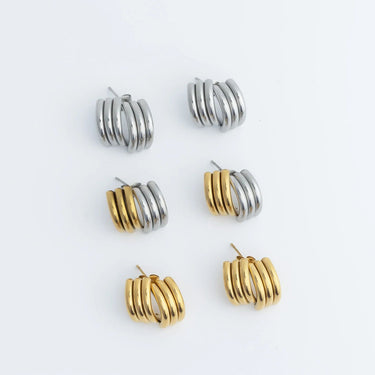 Set of gold and silver hoop earrings on a light gray background