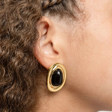 Gold Black Enamel Stud Earrings worn by a person with braided hair.