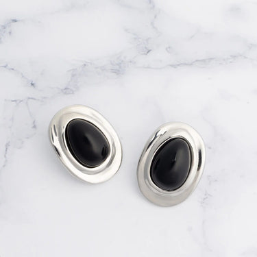 Pair of silver Black Enamel Stud Earrings on a marble background