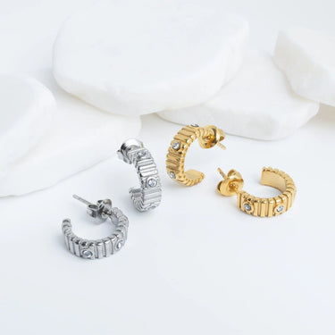 Set of gold and silver hoop Fluted Huggie with Stones Earrings on a white background