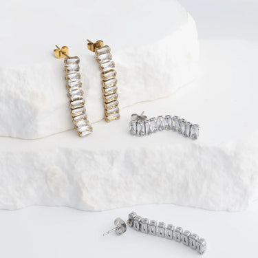 Set of silver and gold hoop earrings on a white surface
