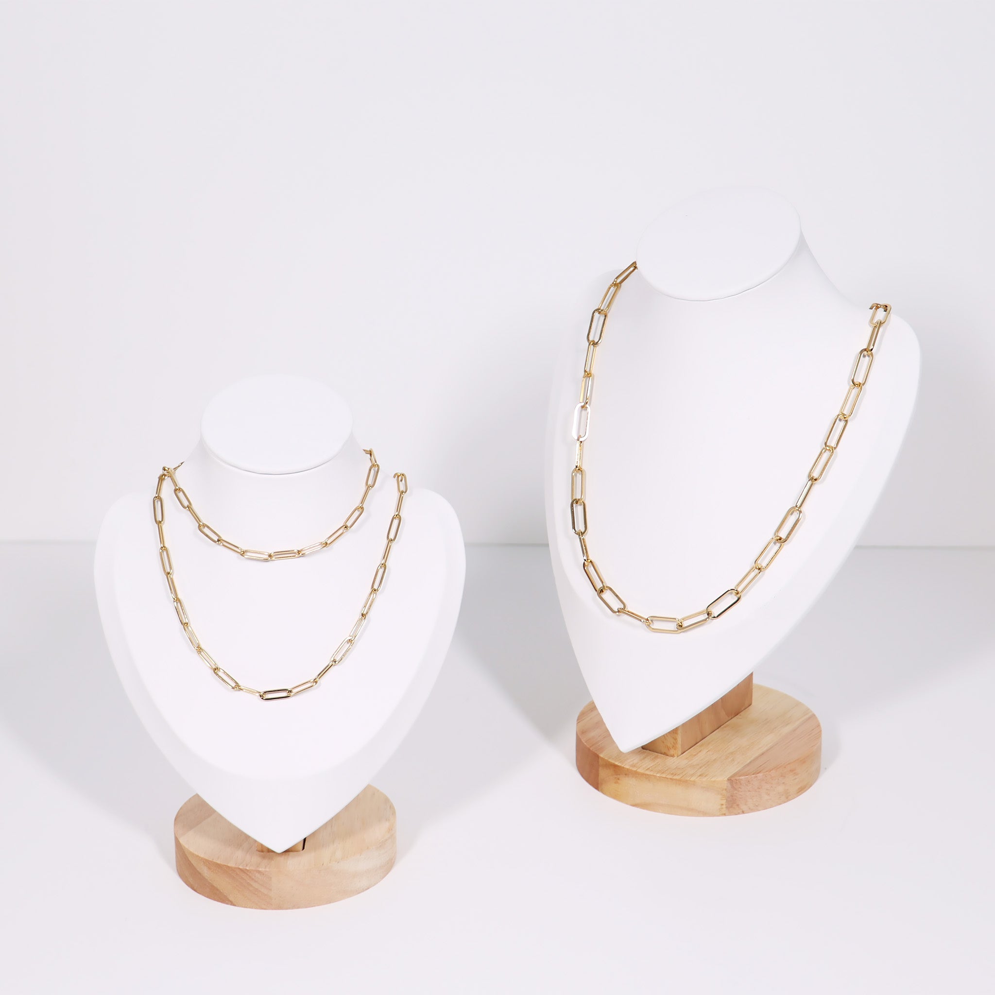 White and wood necklace display showcasing paperclip chain