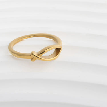 Gold ring with a unique design on a light gray background