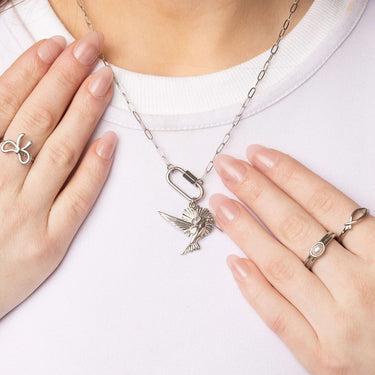 Silver necklace with a pendant worn by a person on a white background