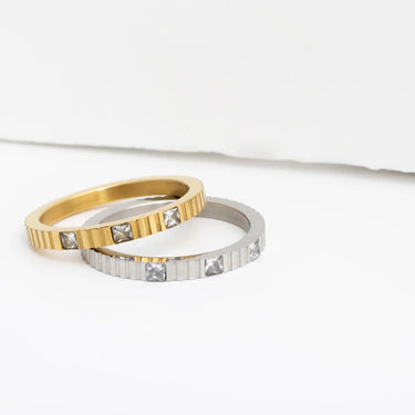 Two gold and silver rings with embedded stones on a white background