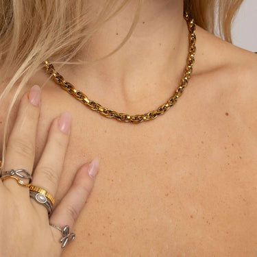 Gold chain necklace worn by a person with visible skin and hair.