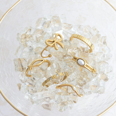 Gold rings on a bed of clear crystals in a glass bowl