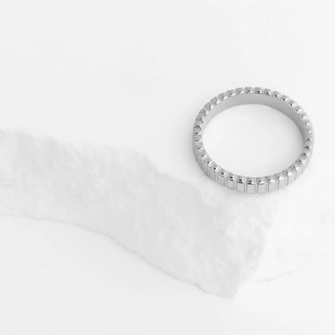 Silver ring on a white fabric background