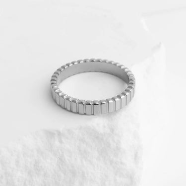 Silver ring with a textured band on a white background