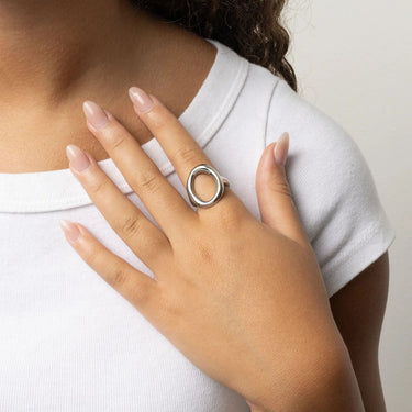 Close-up of a hand wearing a silver Oval Motif Ring  with a white background