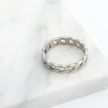 Silver Curb Chain Stacking Ring with a textured band on a white marble surface