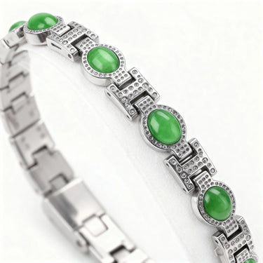 Silver bracelet with green gemstones on a white background