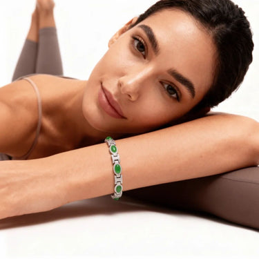 Woman wearing a green and silver bracelet on a white background