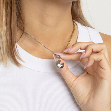 Close-up of a person wearing a necklace with a Fortune Cookie Charm, against a neutral background.