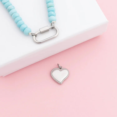 Necklace with a heart-shaped pendant on a pink and white background