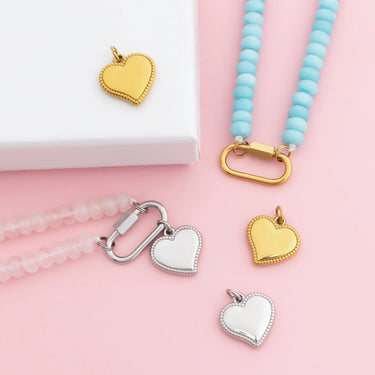 Heart-shaped pendants on necklaces with a pink background