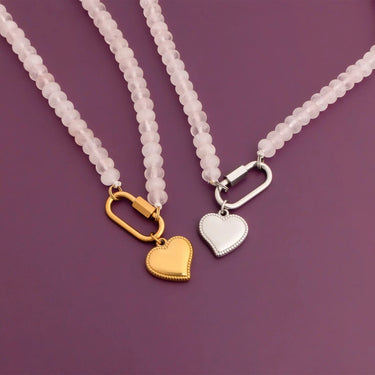 Two necklaces with heart-shaped pendants on a purple background