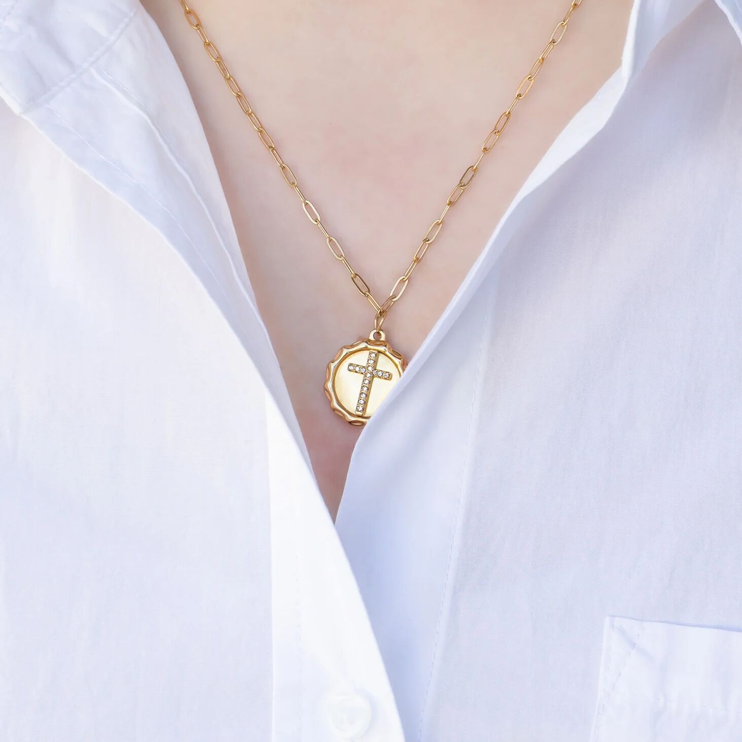 Gold necklace with a cross pendant on a white shirt
