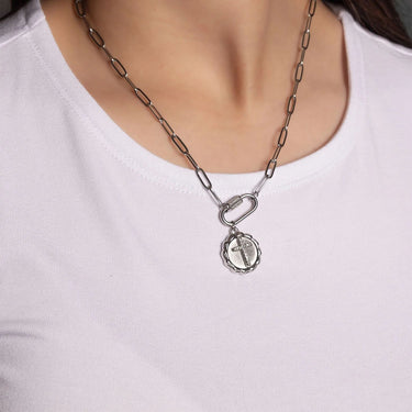 Silver chain necklace with a pendant on a white shirt