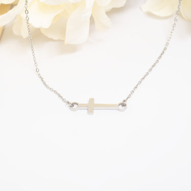 Silver cross necklace on a white background